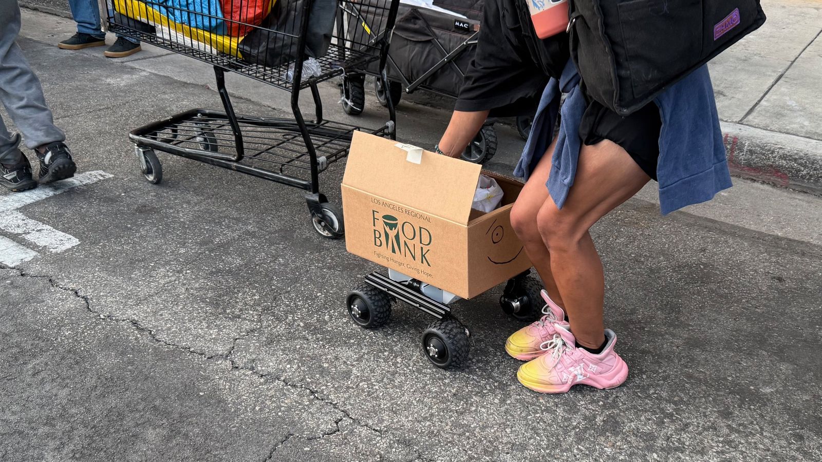 A person on Skid Row opening Food Angel's box to take a meal