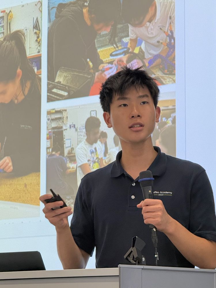 Ethan speaking into a microphone while presenting his research at a conference