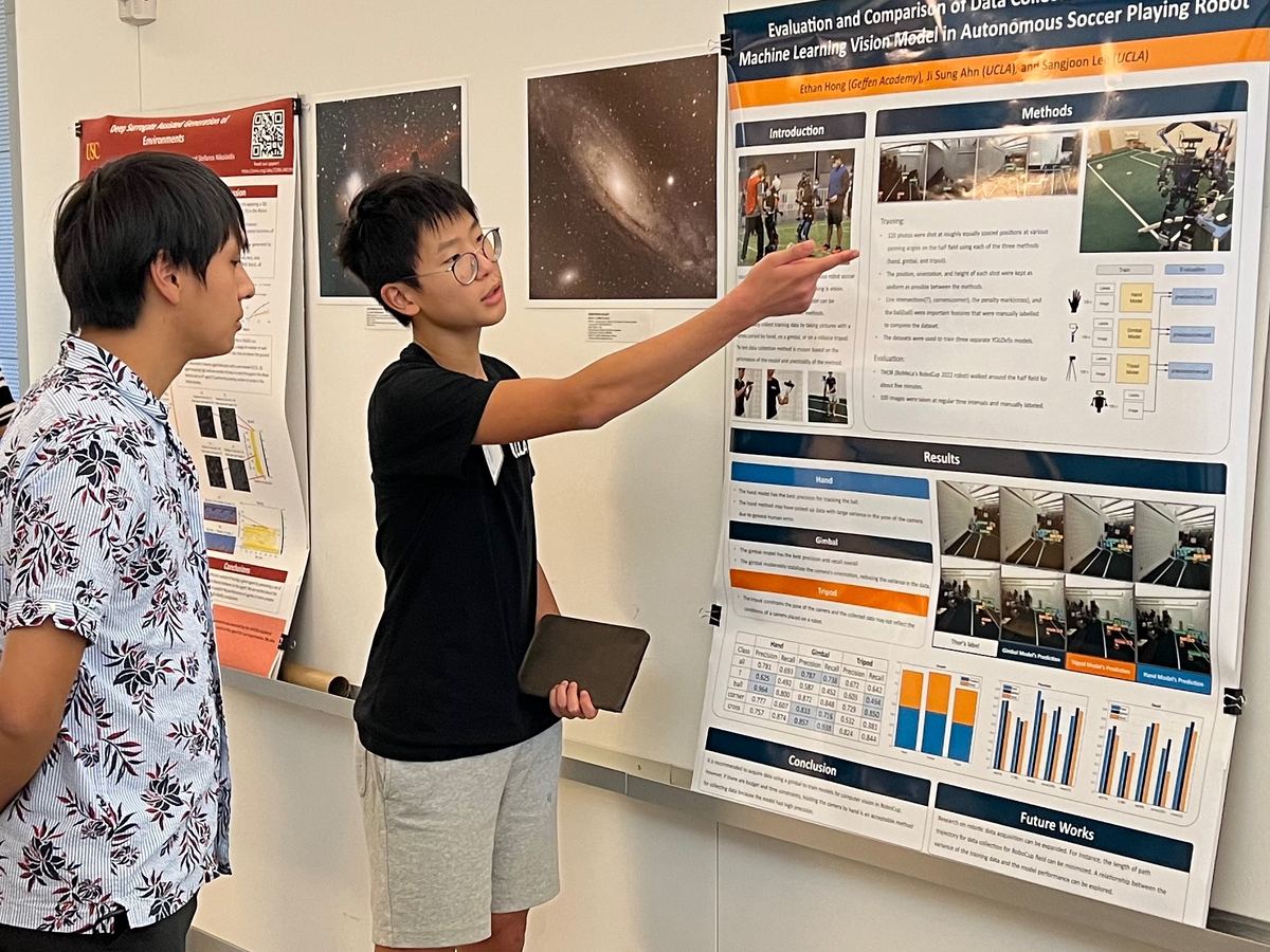 Ethan, as an 8th grader, pointing at his research poster while explaining it to a visitor