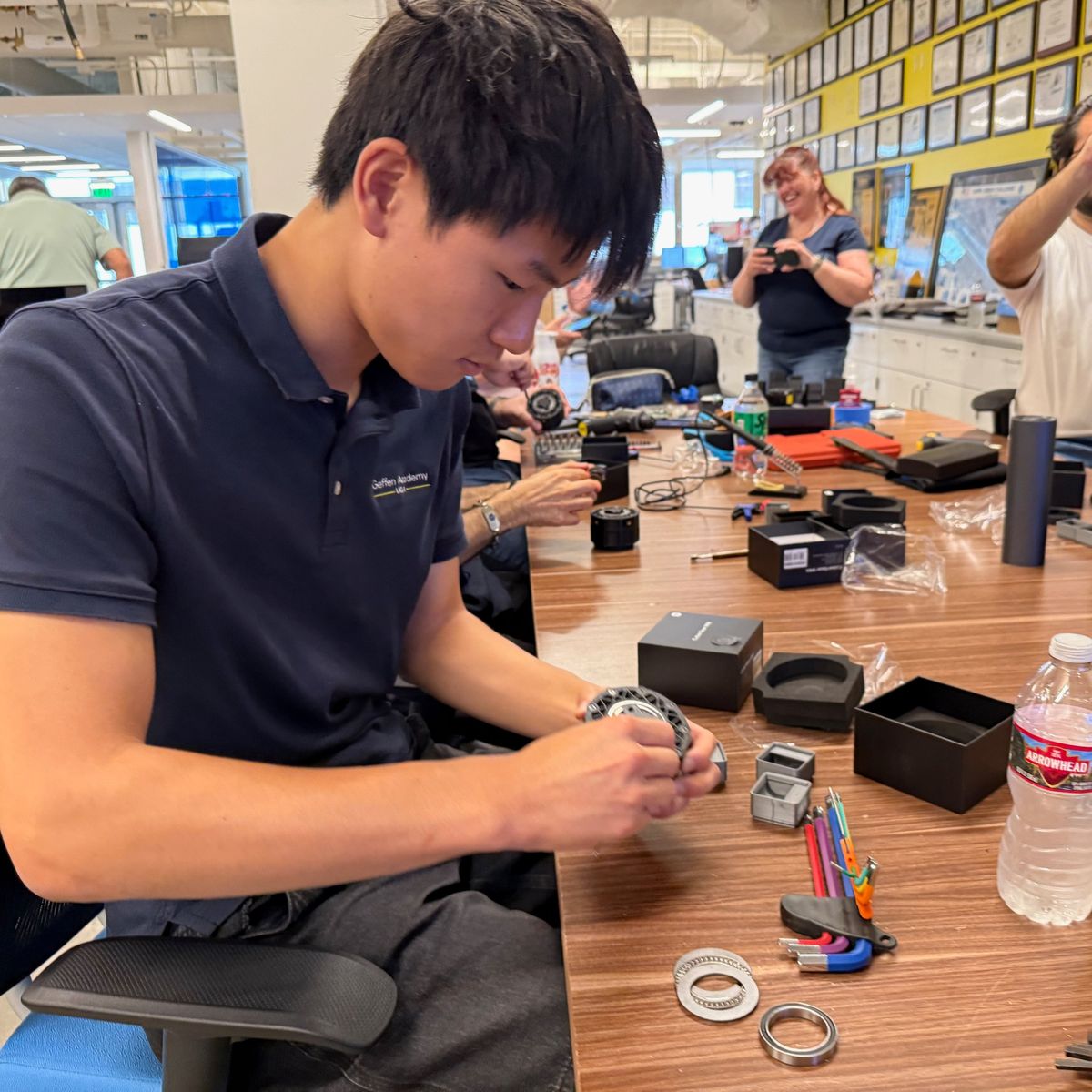 Ethan assembling a robot actuator by hand at a lab worktable